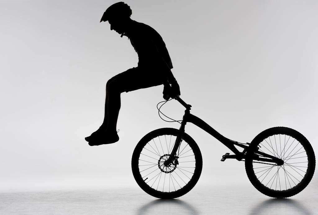 silueta del motociclista de trial realizando acrobacias en bicicleta en blanco
 - Foto, Imagen