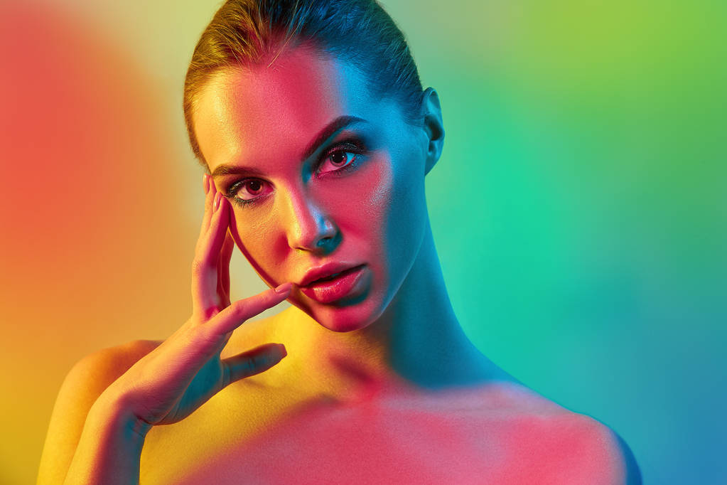 Haute mannequin femme dans des lumières vives colorées posant en studio - Photo, image