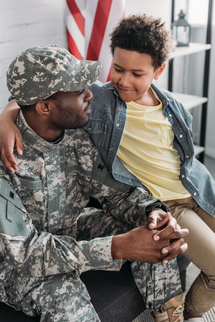 Soldado afroamericano abrazándose con su hijo
 - Foto, Imagen