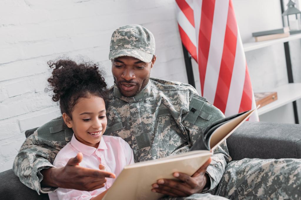 Żołnierz czytanie książki do córki - Zdjęcie, obraz