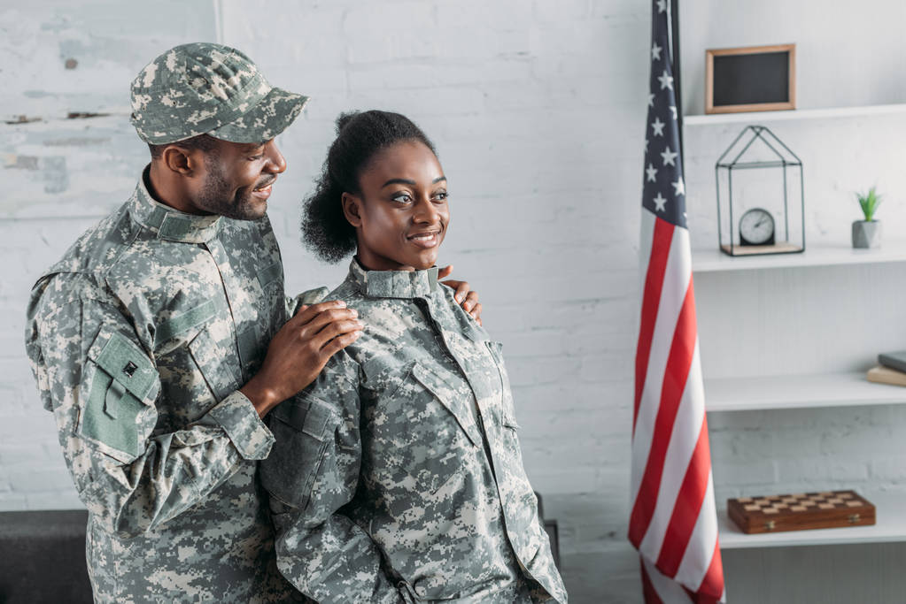 Afrikkalainen amerikkalainen mies sotilas syleilee nainen naamiointi vaatteet
 - Valokuva, kuva