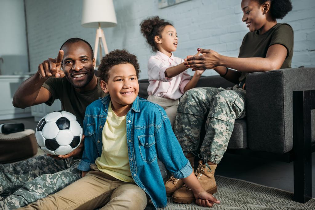 アフリカ系アメリカ人男性と女性兵士の家で子供たちと遊ぶ - 写真・画像