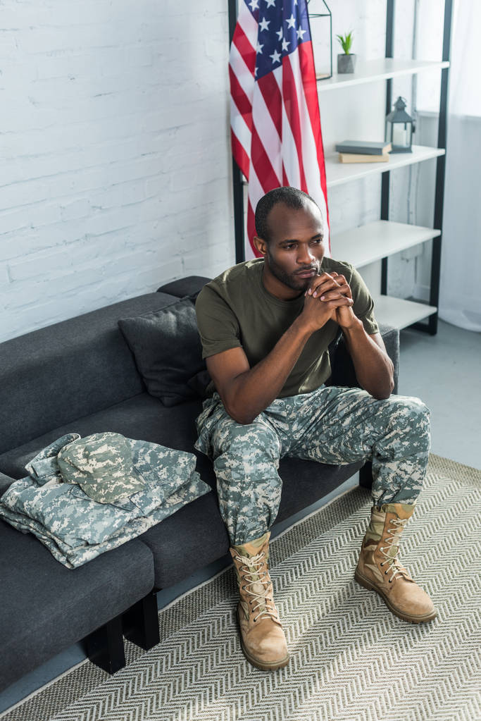 Soldat réfléchi assis sur un canapé avec des vêtements de camouflage
 - Photo, image