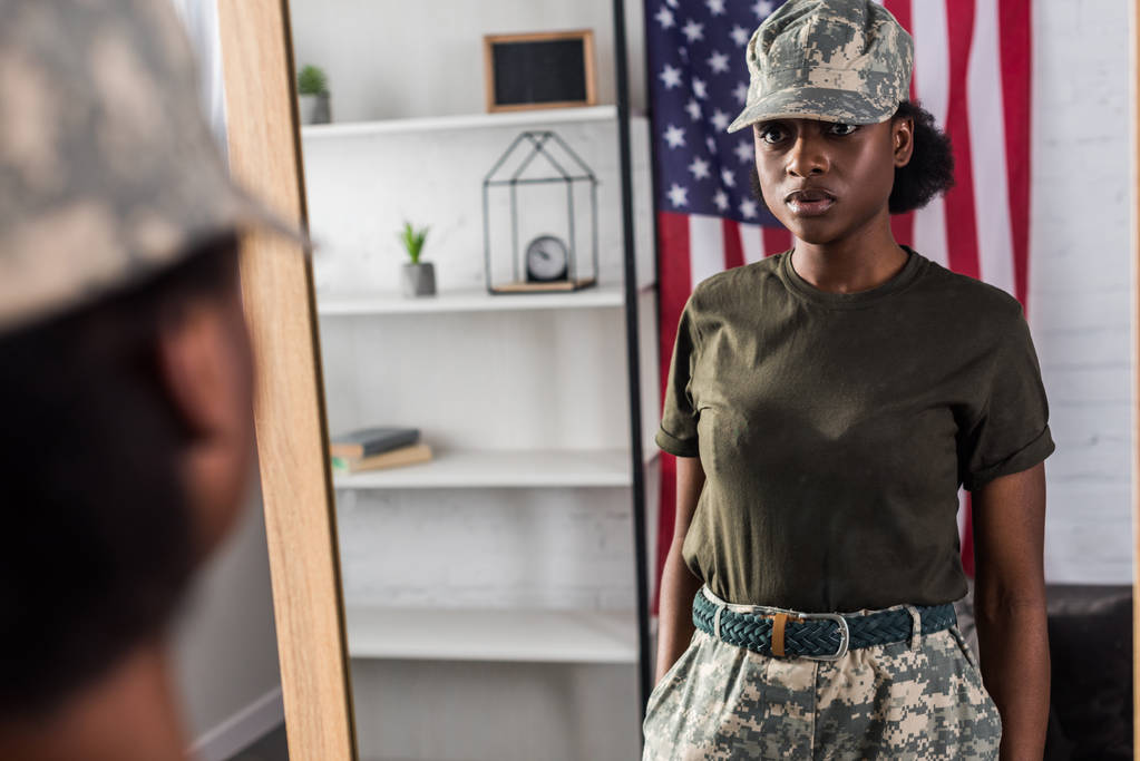 Női katona terepszínű ruhák pózol a tükör által - Fotó, kép