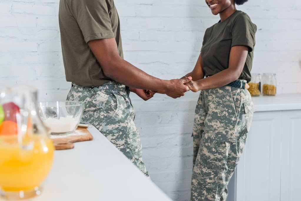 Vue recadrée de soldats afro-américains tenant la main à la cuisine de la maison
 - Photo, image