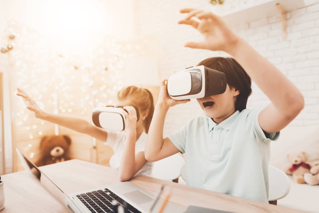 Брат и сестра используют гарнитуры виртуальной реальности дома
 - Фото, изображение