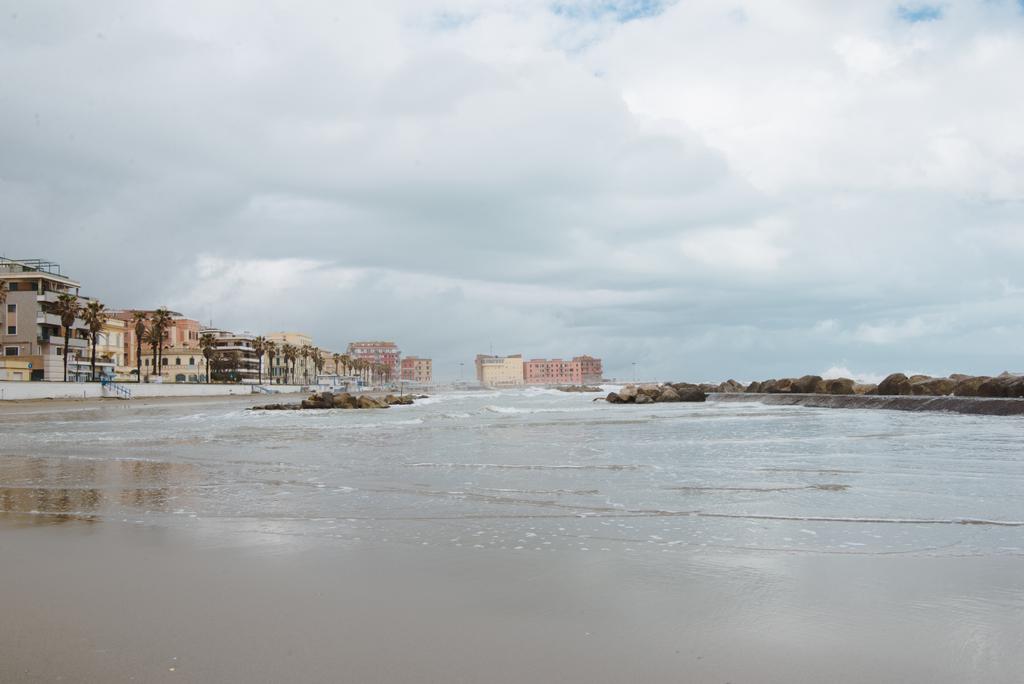 Häuserzeile über der Küste an bewölkten Tagen, Anzio, Italien - Foto, Bild