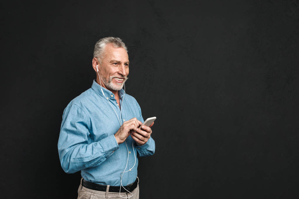 Портрет веселого взрослого мужчины 50-х годов с седыми волосами, печатающего смс или
 - Фото, изображение