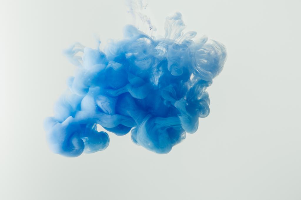 Close up shot of bright blue ink splash in water isolated on gray - Photo, Image