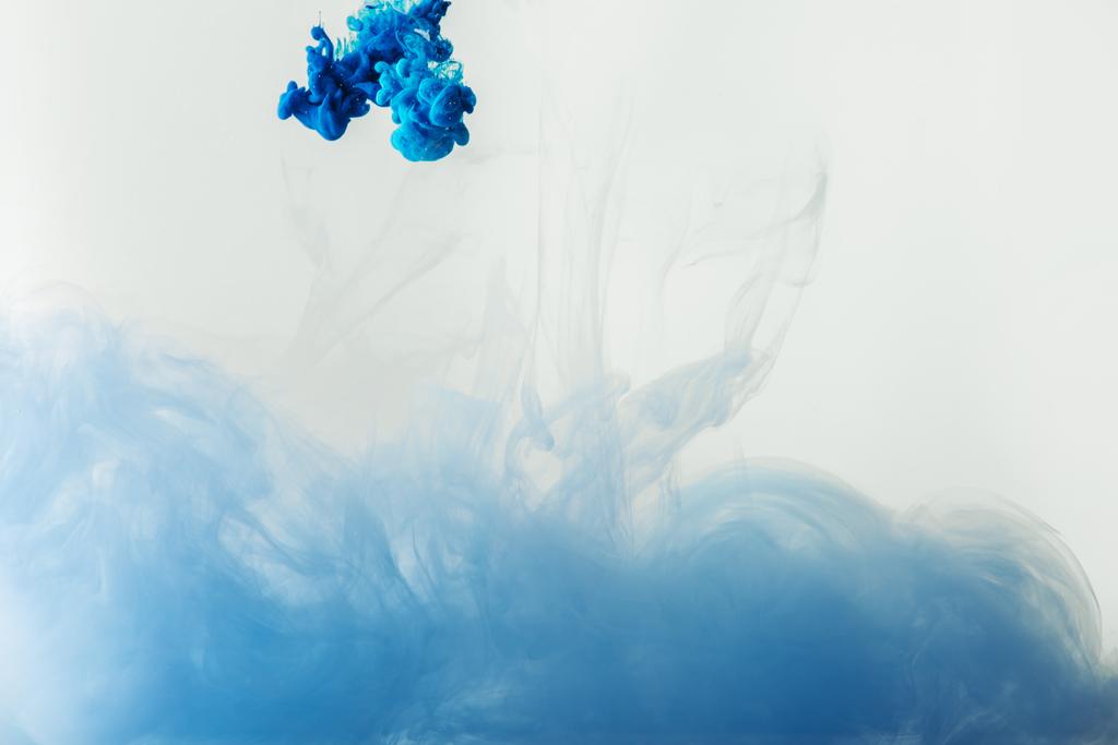 close up view of mixing of blue and light blue paints splashes  in water isolated on gray - Photo, Image