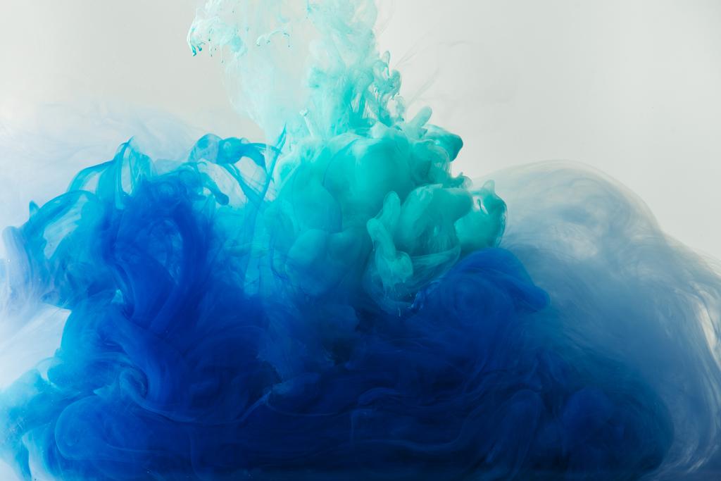 vista de cerca de la mezcla de pinturas azules y turquesas salpicaduras en agua aislada en gris
 - Foto, Imagen