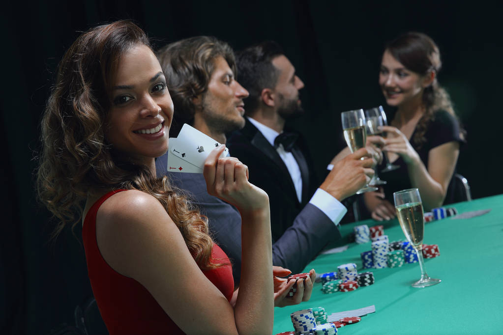Młoda brunetka kobieta gra w pokera na czarnym tle - Zdjęcie, obraz