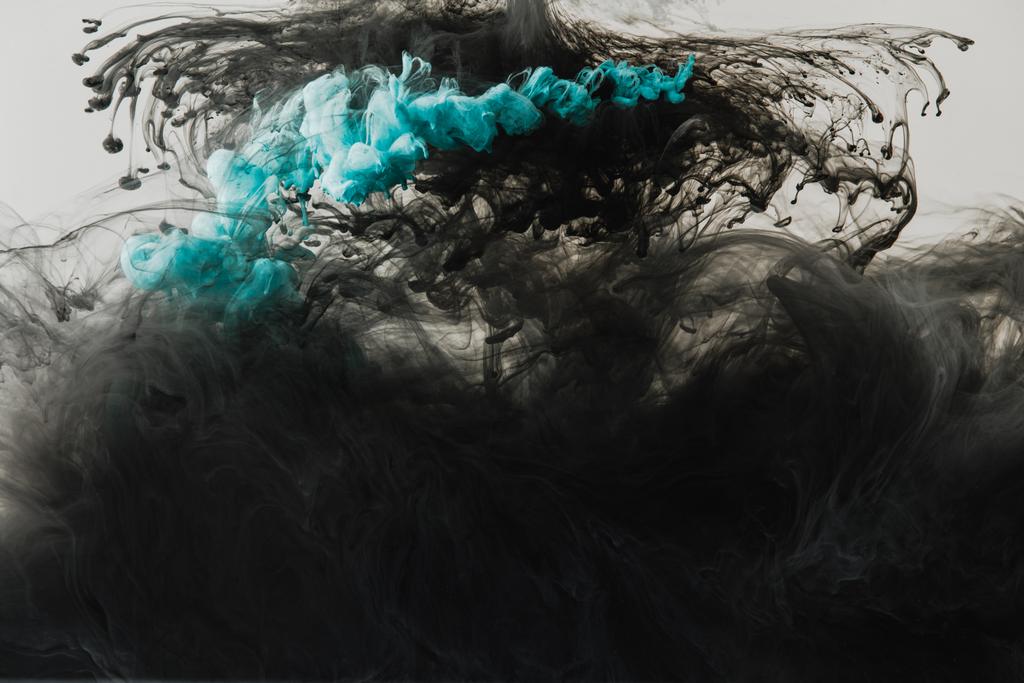 Nahaufnahme des Mischens von hellgrauen, türkisen und schwarzen Farbspritzern im Wasser isoliert auf grau - Foto, Bild