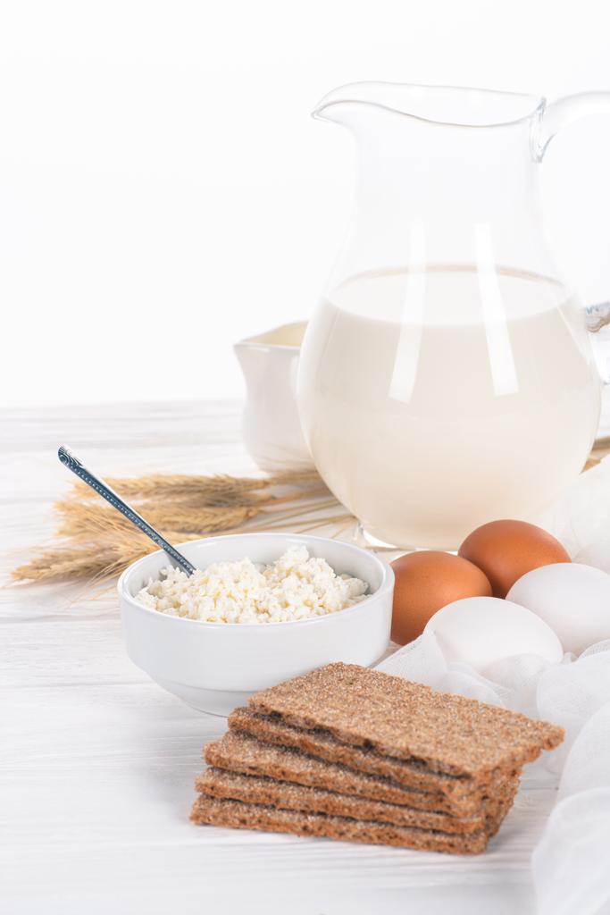 close-up view of crispy crackers, eggs, milk and cottage cheese on wooden table  - Photo, Image