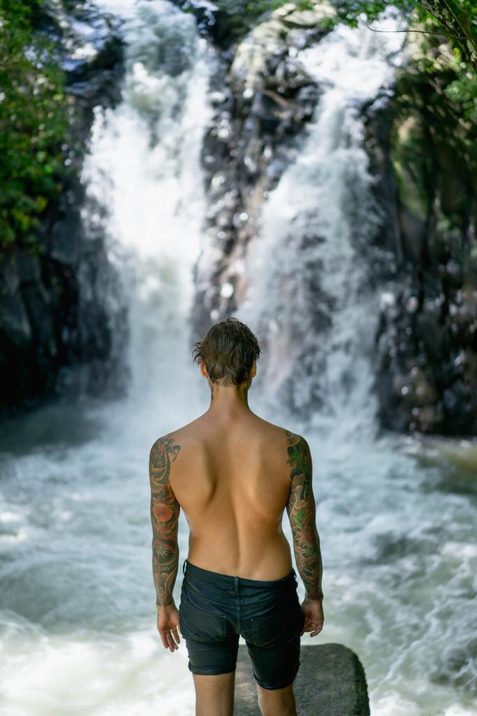 takaisin näkymä tatuoitu mies seisoo Aling-Aling Vesiputous taustalla, Bali, Indonesia
 - Valokuva, kuva