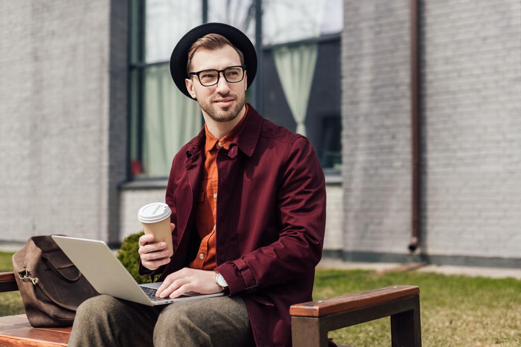bell'uomo elegante con caffè per andare con il computer portatile
 - Foto, immagini
