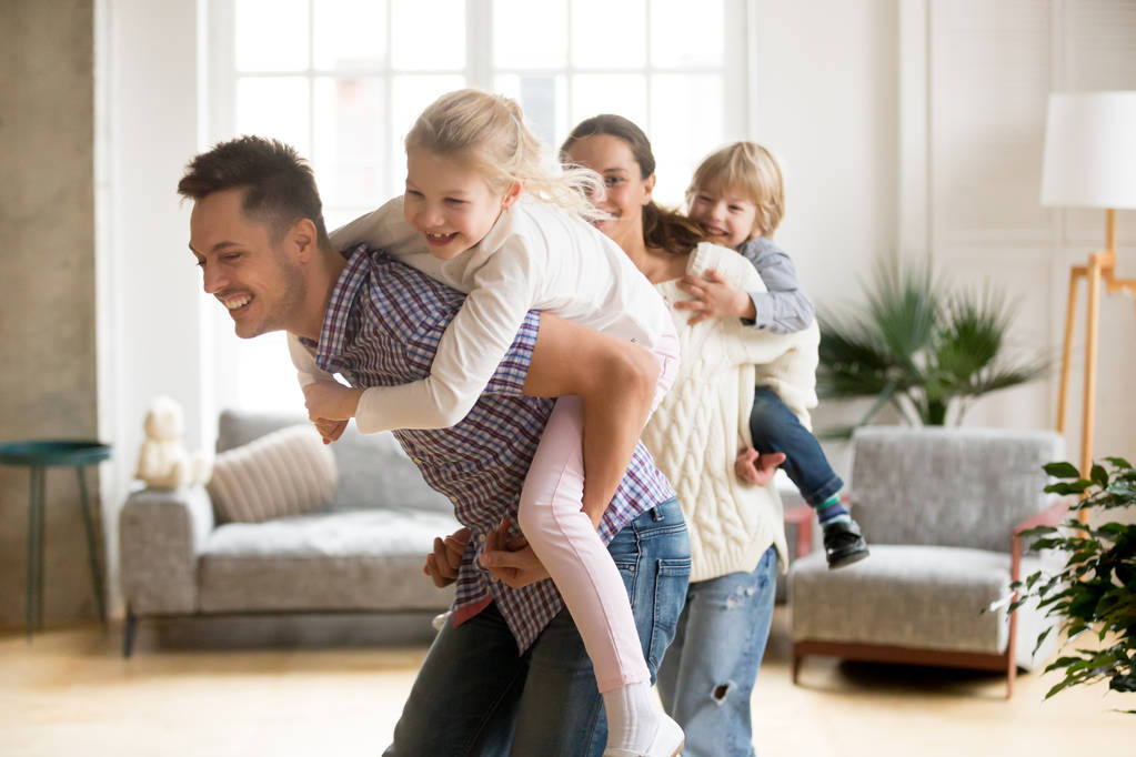Adorável pai piggybacking pequena filha brincando com a família em h
 - Foto, Imagem