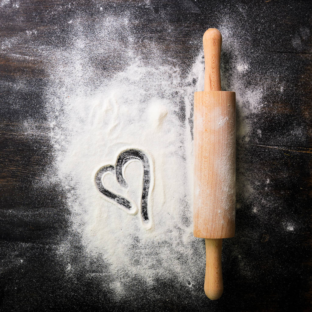 Baking background. Heart of flour and rolling pin on dark table with copy space, top view. Valentines Day - Photo, Image