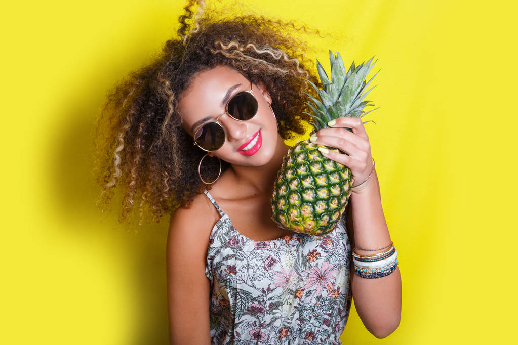Mode portrait d'été afro américaine femme en lunettes de soleil et ananas sur fond jaune
 - Photo, image