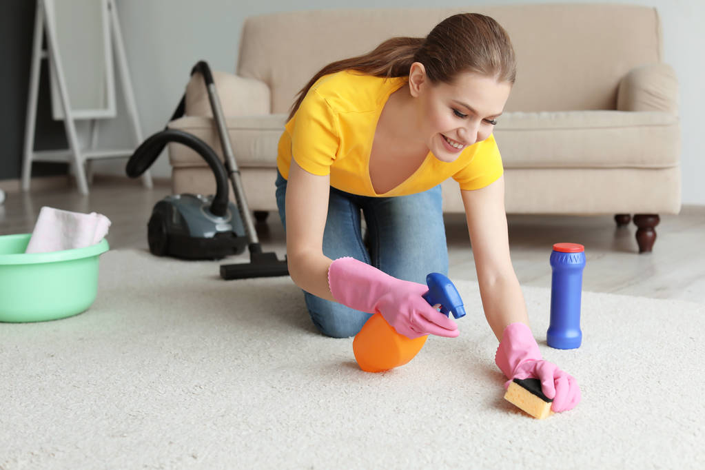 Jovem mulher limpeza tapete em casa
 - Foto, Imagem