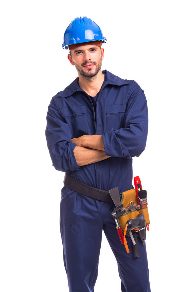 Πορτρέτο του ένας σοβαρός νέος εργαζόμενος στέκεται με τα χέρια σταυρωμένα σε λευκό φόντο - Φωτογραφία, εικόνα