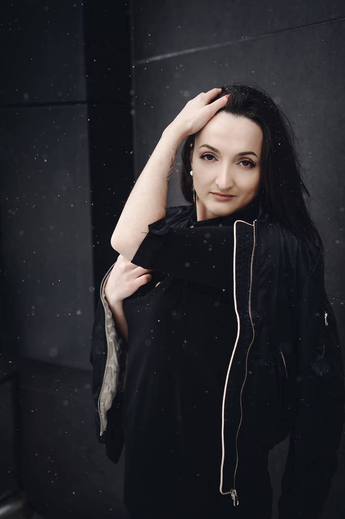 Вуличний портрет жінки. модна брюнетка в чорному одязі за стилем, ходьба на відкритому повітрі в сезони. снігопади в рамці
 - Фото, зображення