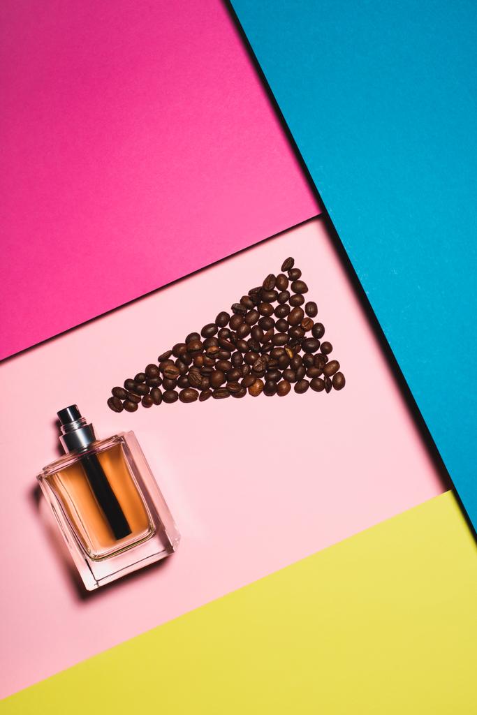 vista superior de garrafa de vidro de perfume com grãos de café na superfície colorida
 - Foto, Imagem