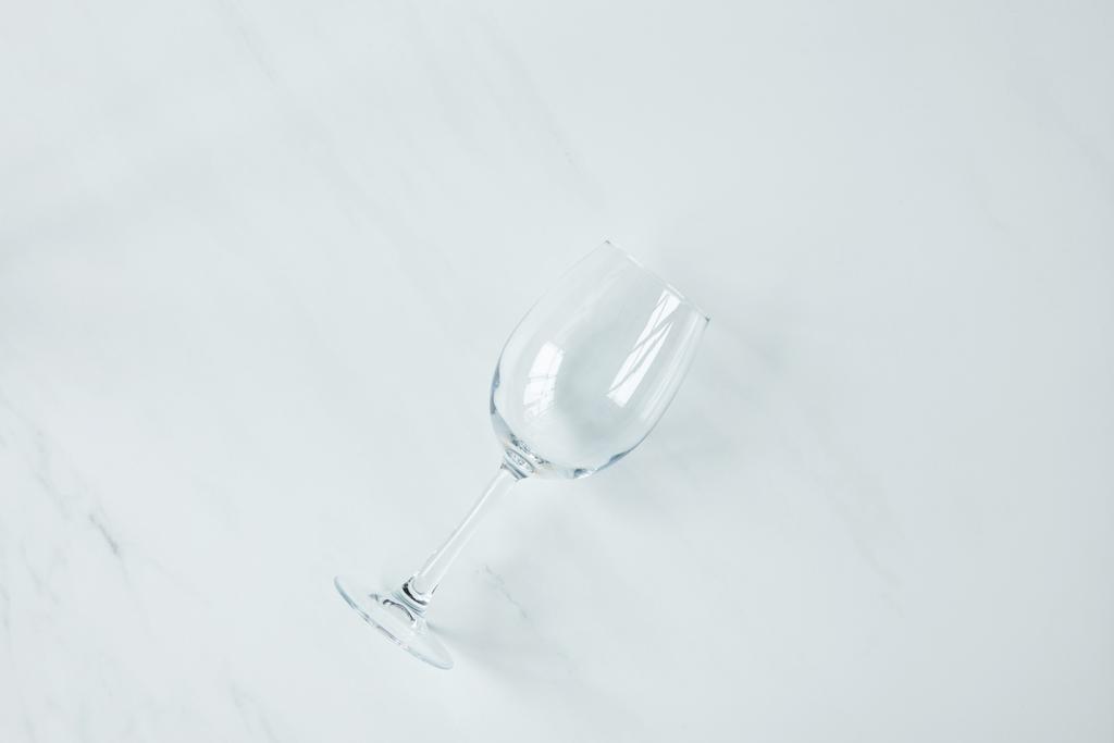 bovenaanzicht van lege wijnglas op marmeren tafelblad - Foto, afbeelding