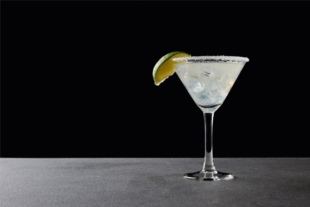 vista da vicino di gustoso cocktail margarita con lime e ghiaccio su tavolo su nero
 - Foto, immagini