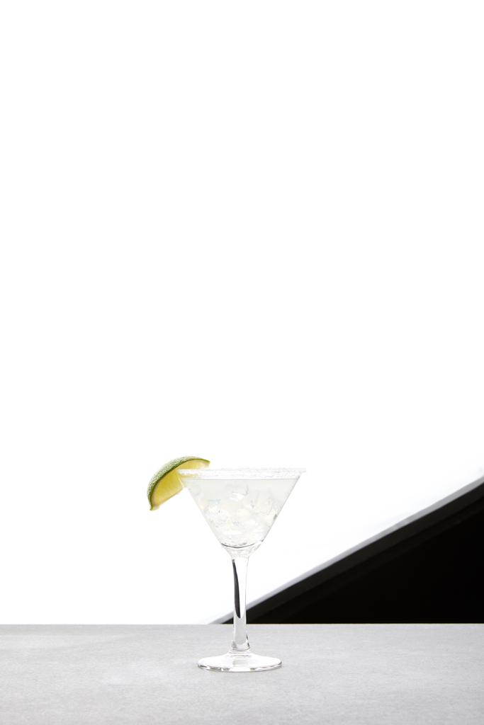 close up view of margarita cocktail with lime and ice on tabletop on black and white backdrop - Photo, Image