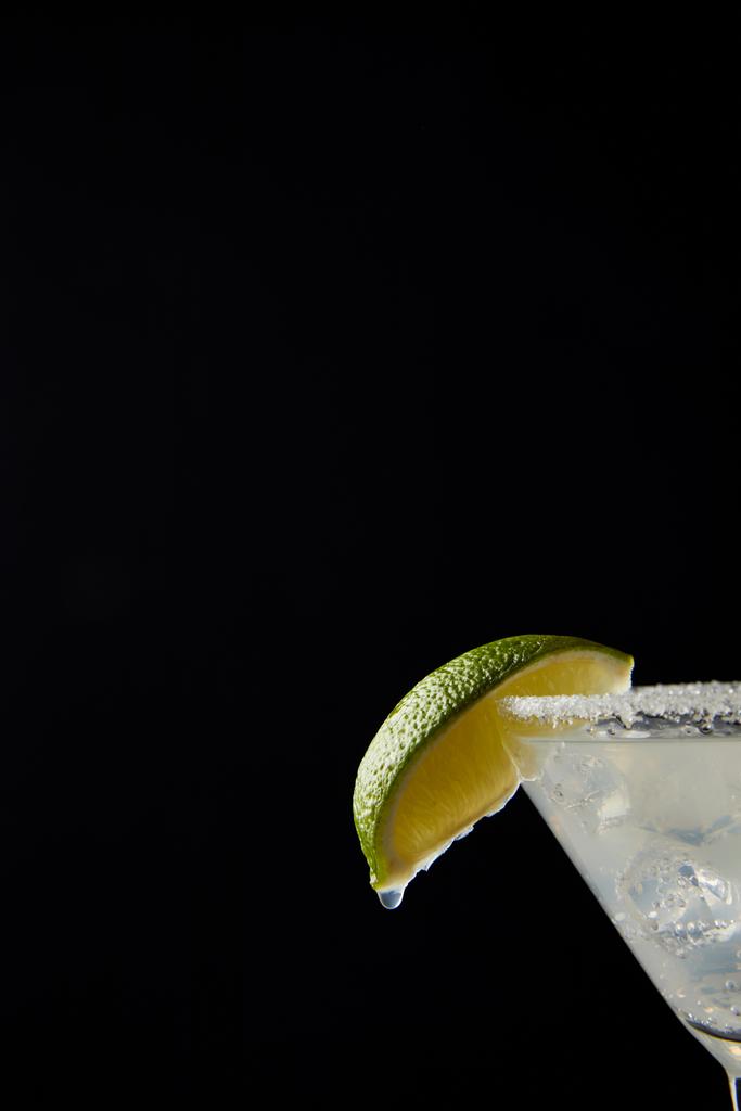 Закрыть вид на холодный коктейль Маргариты с лаймом, изолированным на черном
 - Фото, изображение
