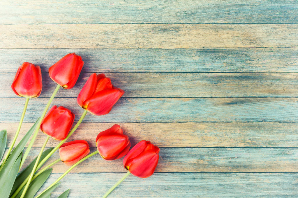 kytice červených tulipánů na pozadí světle modré dřevěné retro grunge s kopie prostoru. Koncept matky den, dámské, pohled shora - Fotografie, Obrázek