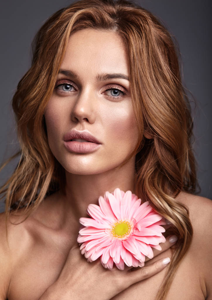 Schönheit Mode Porträt der jungen blonden Frau Modell mit natürlichem Make-up und perfekte Haut mit leuchtend rosa Gerbera Blume posiert in Studi - Foto, Bild