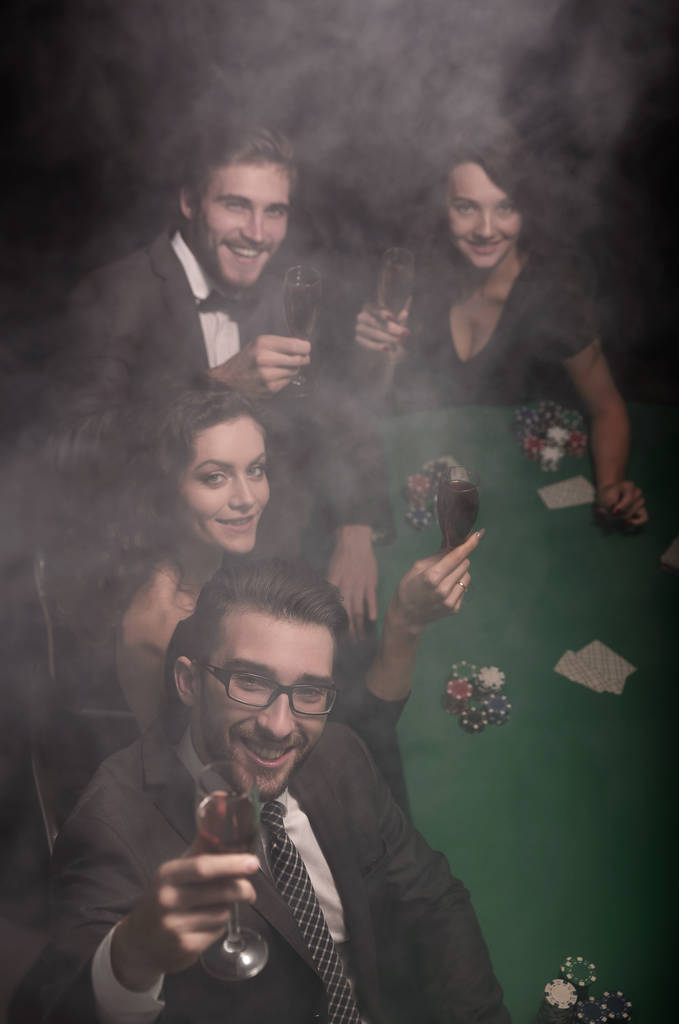 Grupo de jóvenes ricos está jugando al poker en el casino
 - Foto, Imagen