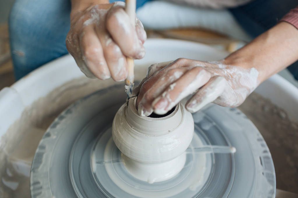 Artesanal na roda de um oleiro, as mãos fazem argila de vários itens para casa e venda na loja e na exposição, os itens cerâmicos são feitos na mão, o tarugo de argila se torna um prato de cerâmica
 - Foto, Imagem
