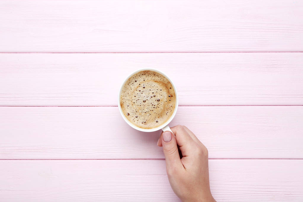 Nainen käsi tilalla kuppi kahvia puinen tausta
 - Valokuva, kuva