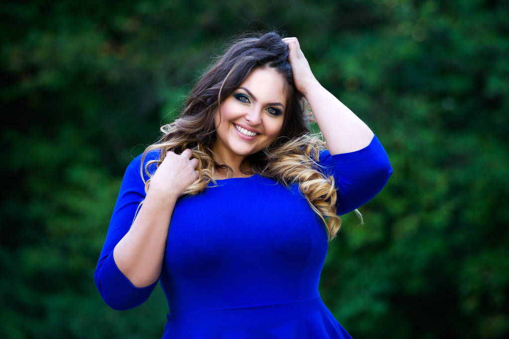 Happy plus size fashion model in blue dress outdoors, happiness beauty woman with professional makeup and hairstyle - Photo, Image