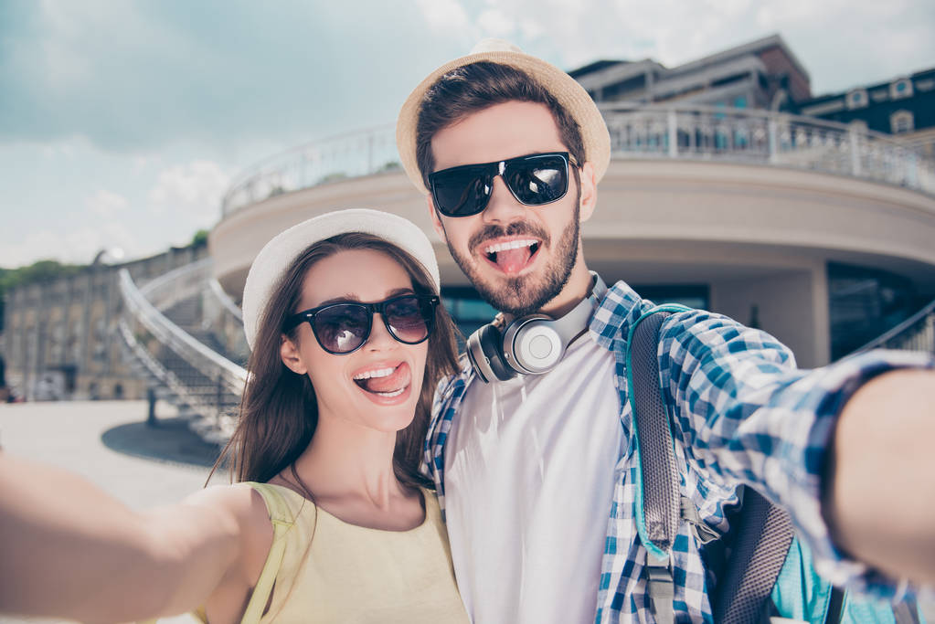 Elegante pareja divertida atractiva de moda en gorras teniendo viaje tr
 - Foto, imagen