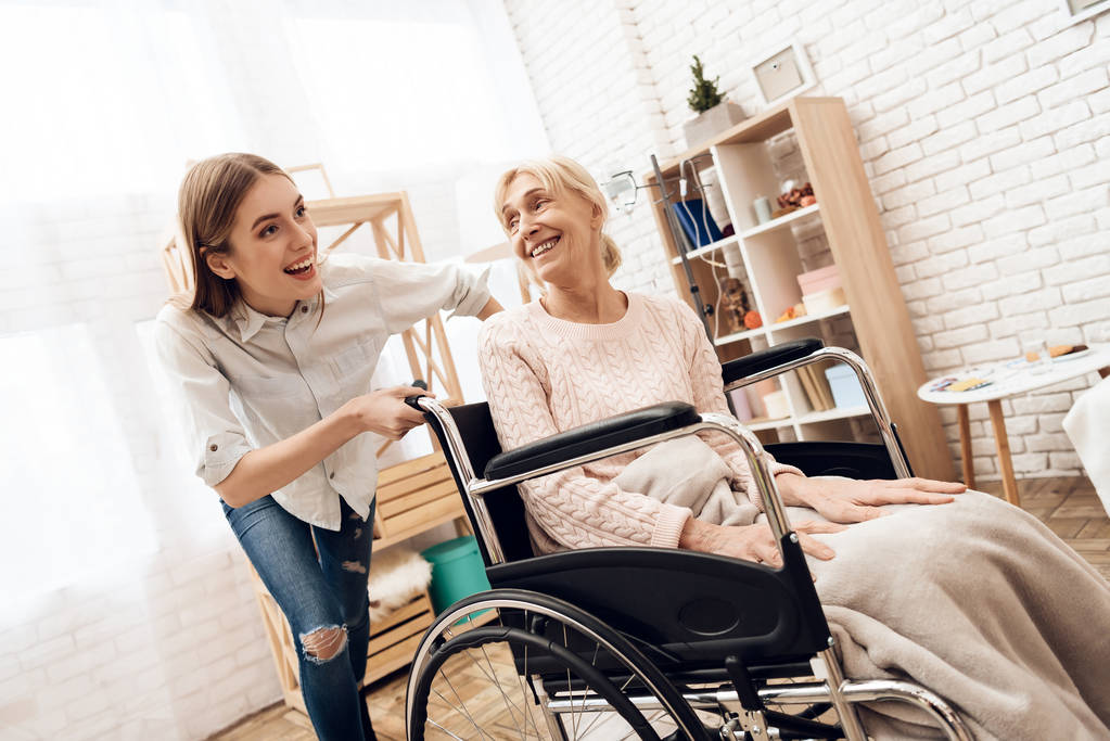 高齢女性の自宅を看護と車椅子に乗って彼女の女の子 - 写真・画像