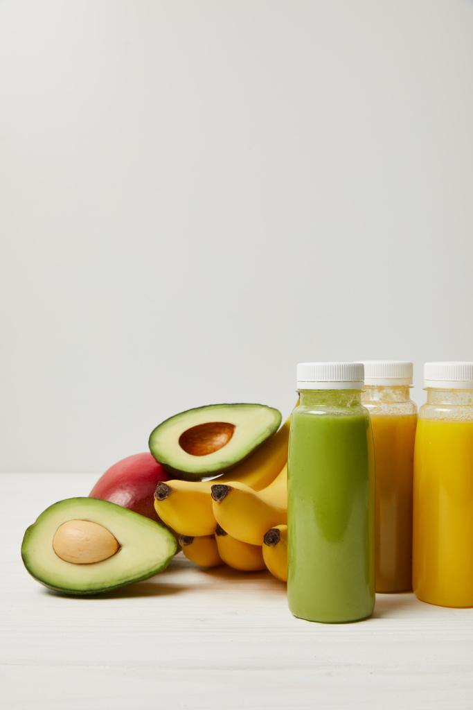 frutas desintoxicantes frescas e smoothies em garrafas no fundo branco
   - Foto, Imagem