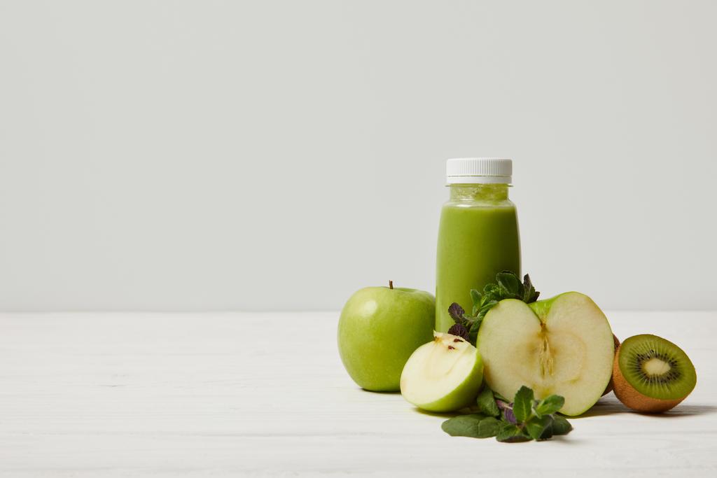 detox πράσινο smoothie με μήλα, ακτινίδια και δυόσμο και στην λευκή ξύλινη επιφάνεια     - Φωτογραφία, εικόνα