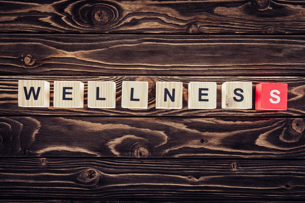 a wellness szó barna fa felület rendezett fa tömb felülnézet - Fotó, kép