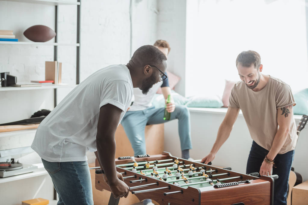 two young multiethnic friends playing table football - Photo, Image
