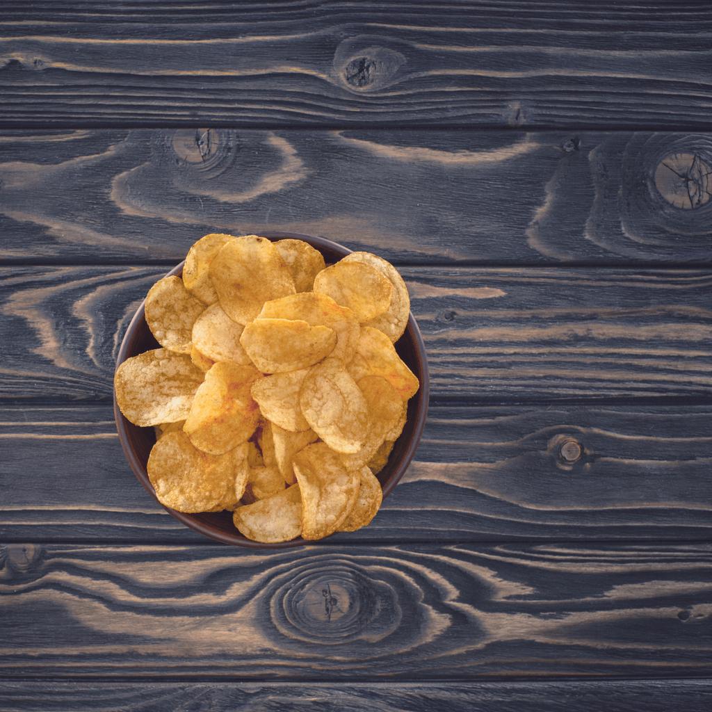 ahşap masa üzerinde kase gevrek sağlıksız patates cipsi Üstten Görünüm   - Fotoğraf, Görsel