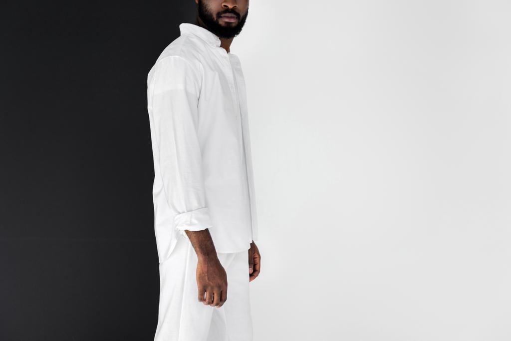 image recadrée de l'homme afro-américain élégant en vêtements blancs sur noir et blanc
 - Photo, image