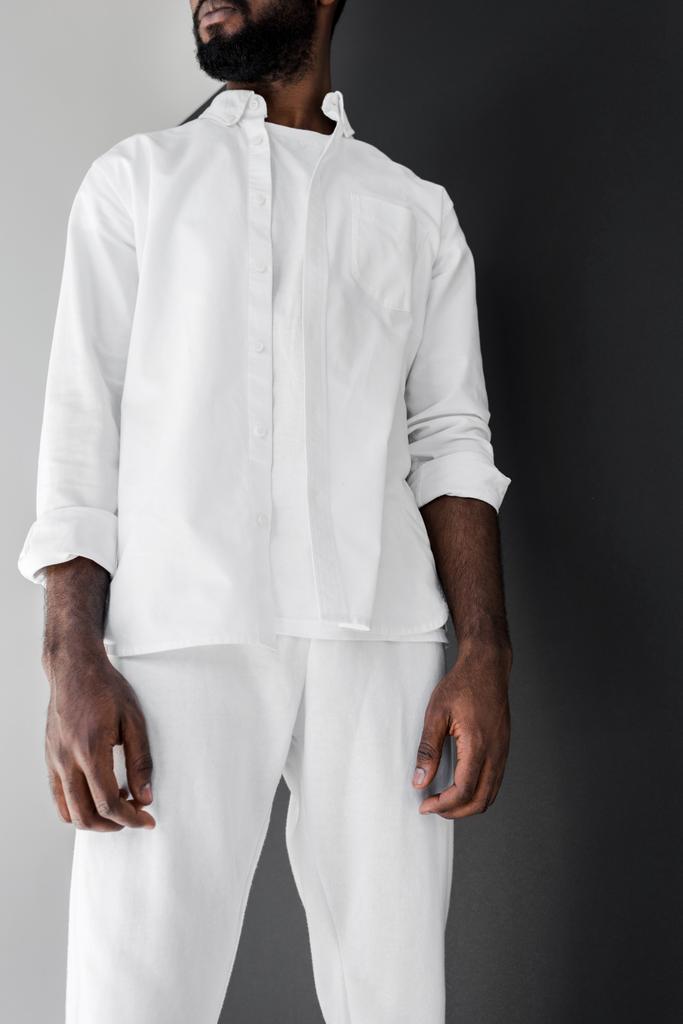 körülvágott kép elegáns afroamerikai férfi állandó fehér ruhát - Fotó, kép