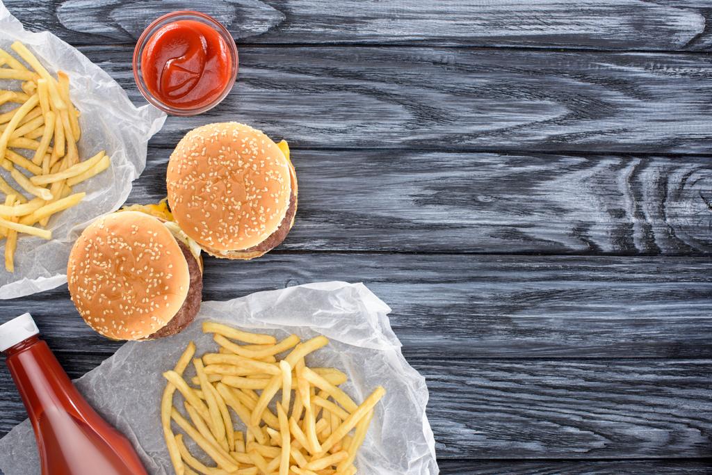 vista superior de hamburguesas con papas fritas y ketchup en mesa de madera
     - Foto, Imagen