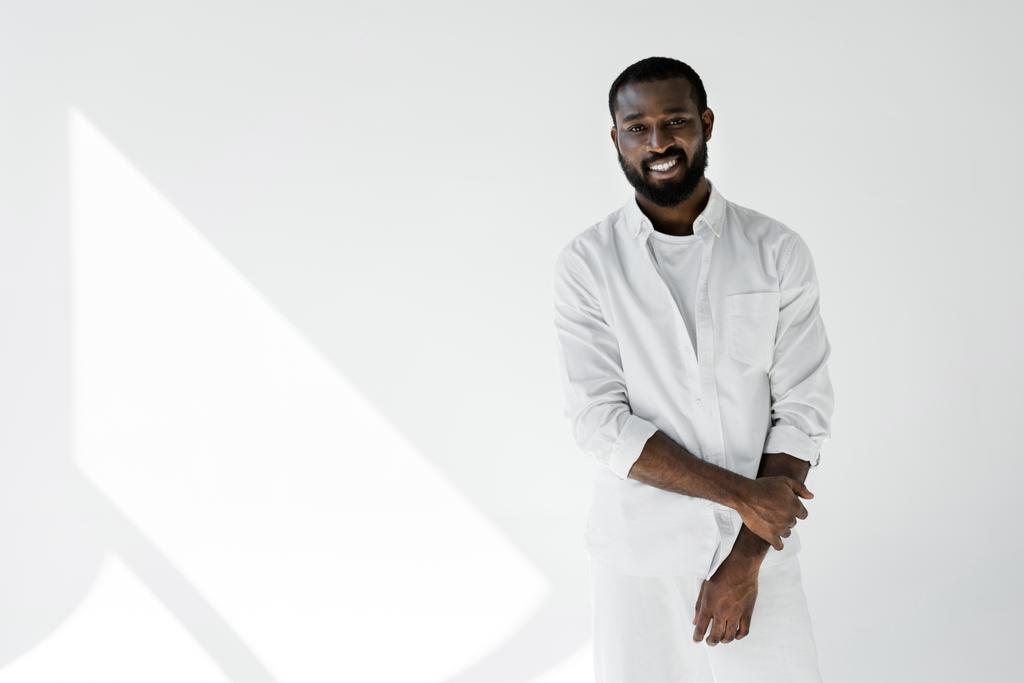 mosolygó elegáns afrikai amerikai férfi, fehér ruhát látszó-nél fényképezőgép fehér - Fotó, kép