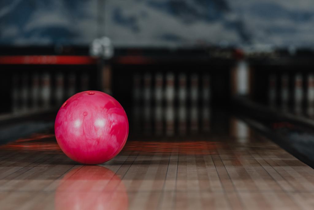 Close-up shot van rode bowlingbal liggend op alley - Foto, afbeelding