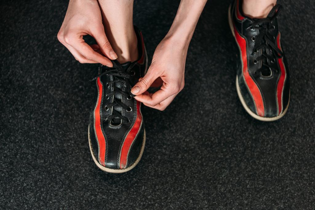 обрізаний знімок жінки, що зв'язує прокат взуття для боулінгу
 - Фото, зображення